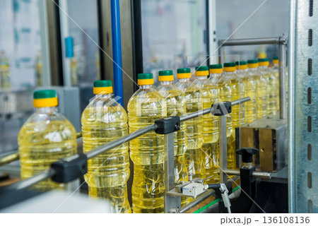 Bottling line of sunflower oil in bottles. Vegetable oil production plant Bottling line of sunflower oil in bottles. Vegetable oil production plant 136108136