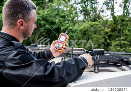 Technician use hand-held anemometer measuring air flowing measurement 136108372