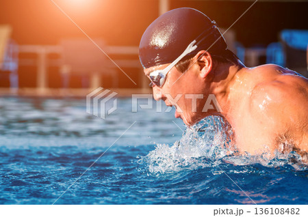 Young athletic man swimming in the swimming pool 136108482