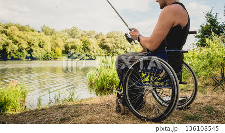Handicapped man fishing at a lake. Wheelchair camping. Handicapped man fishing at a lake. Wheelchair camping. 136108545