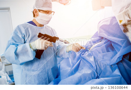 Arthroscope surgery. Orthopedic surgeons in teamwork in the operating room  136108644