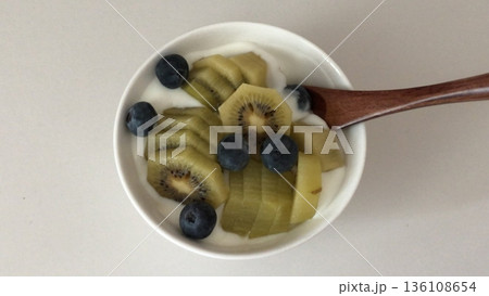Greek yogurt served in a bowl topped with fresh colorful fruits, showcasing creamy smooth texture, vibrant natural colors, and refreshing wholesome appearance in close-up detail Greek yogurt served in a bowl topped with fresh colorful fruits, showcasing creamy smooth texture, vibrant natural colors, and refreshing wholesome appearance in close-up detail 136108654