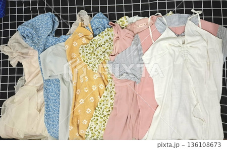 Clothes hanging neatly on hangers under the sun, gently swaying in the breeze—offering a perfect glimpse of fresh laundry days, clean fabric, and simple everyday beauty in every scene. 136108673