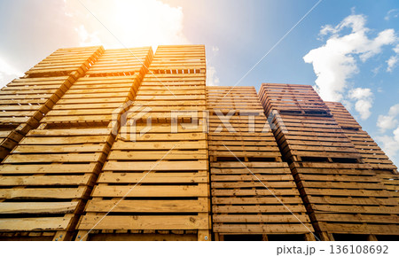 Wooden boxes stacked on each other. Outdoors. Blue sky background Wooden boxes stacked on each other. Outdoors. Blue sky background 136108692