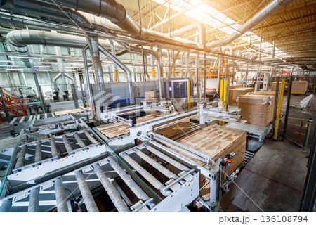 Production line of the wooden floor factory. CNC automatic woodworking machine. Production line of the wooden floor factory. CNC automatic woodworking machine. 136108794