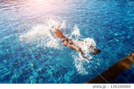 Young athletic man swimming in the swimming pool 136108860
