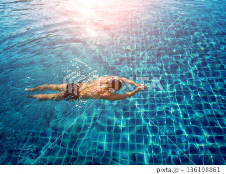 Young athletic man swimming in the swimming pool 136108861