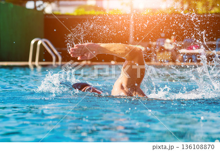Young athletic man swimming in the swimming pool Young athletic man swimming in the swimming pool 136108870