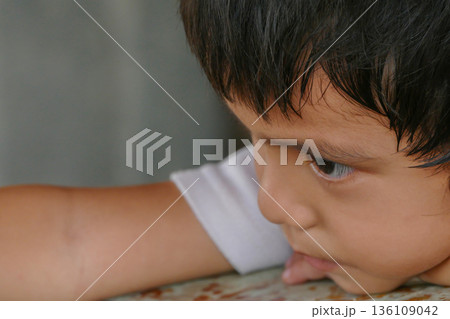Closeup cute portrait of Asian little boy absent-minded 136109042
