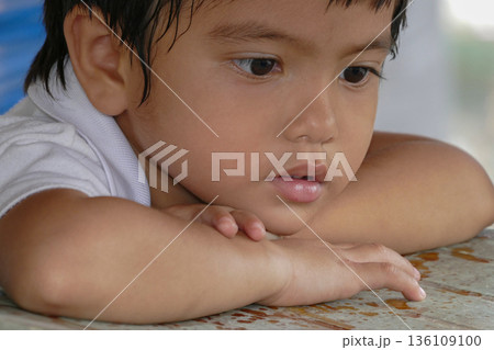 Closeup cute portrait of Asian little boy absent-minded 136109100