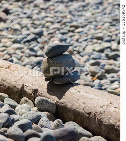 Pile of balanced round stones on the beach 136109542