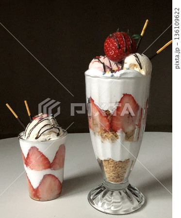 Healthy breakfast of strawberry parfait made with fresh fruit, and yogurt over a rustic white table. Selective focus with blurred background and foreground. Healthy breakfast of strawberry parfait made with fresh fruit, and yogurt over a rustic white table. Selective focus with blurred background and foreground. 136109622