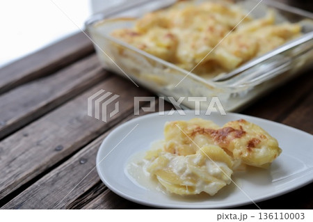 取り分けたフランスの家庭料理ドフィノア風じゃがいもグラタン 136110003