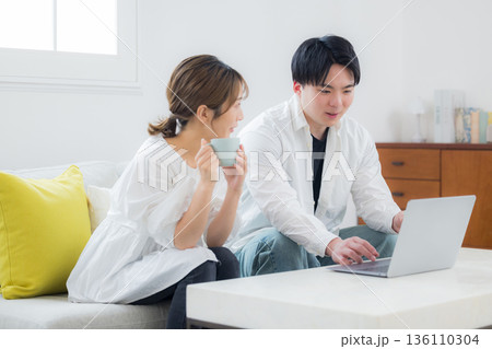 パソコンを見る若いカップル 136110304