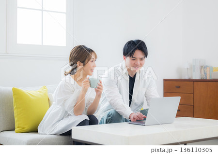 パソコンを見る若いカップル 136110305