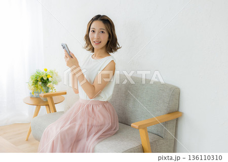 スマホを見る笑顔の女性 136110310