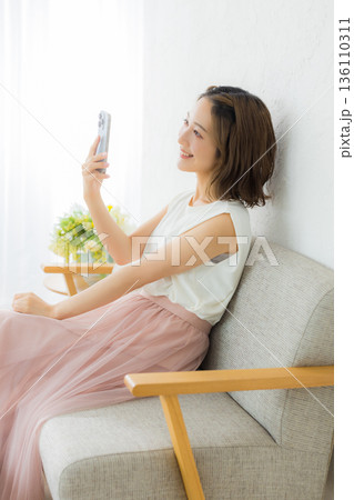 スマホを見る笑顔の女性 136110311