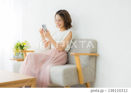 スマホを見る笑顔の女性 136110312