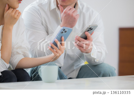 スマホを見る若いカップル 136110335