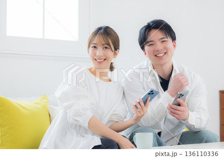 スマホを見る若いカップル スマホを見る若いカップル 136110336