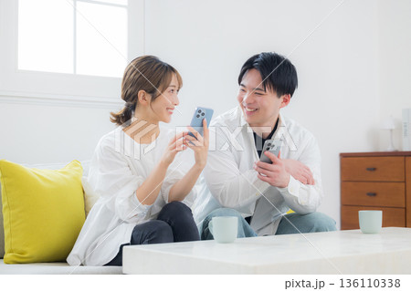 スマホを見る若いカップル 136110338