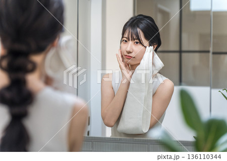 洗顔後に鏡を見ながら肌チェックする若いアジア人女性(肌トラブル,乾燥,スキンケア,皮膚トラブル) 洗顔後に鏡を見ながら肌チェックする若いアジア人女性(肌トラブル,乾燥,スキンケア,皮膚トラブル) 136110344