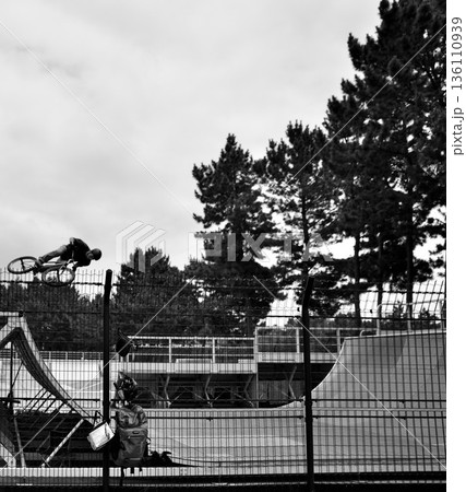 スケートパークでジャンプするBMXライダー モノクロのアクション 136110939