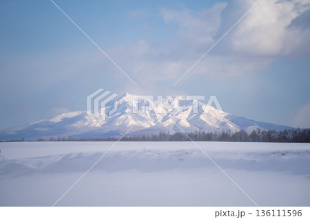 雪原の先にそびえる冬の斜里岳と澄んだ青空の景色 雪原の先にそびえる冬の斜里岳と澄んだ青空の景色 136111596