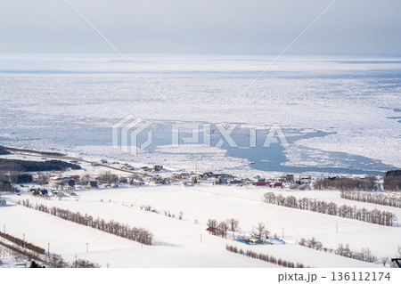 流氷が広がるオホーツク海を望む冬の北海道道東の大地と空が織りなす静寂の風景写真 136112174
