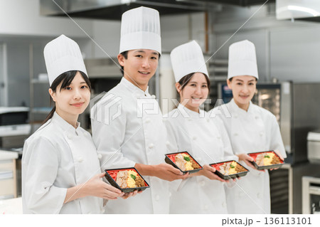 厨房・キッチンに立つコックコート姿の調理師・シェフ・コックの男女(お弁当,お惣菜) 厨房・キッチンに立つコックコート姿の調理師・シェフ・コックの男女(お弁当,お惣菜) 136113101