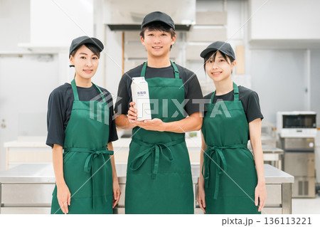 牛乳パックを持つキッチン・バックヤードにいるキッチンスタッフ・調理スタッフの男女 136113221