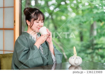 旅館の和室でお茶を飲む浴衣姿の若いアジア人女性 136113989