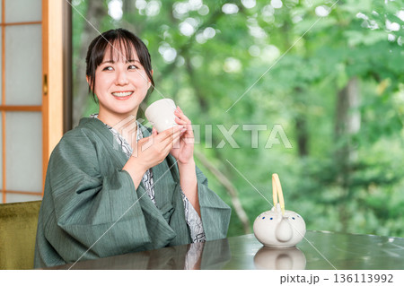 旅館の和室でお茶を飲む浴衣姿の若いアジア人女性 旅館の和室でお茶を飲む浴衣姿の若いアジア人女性 136113992