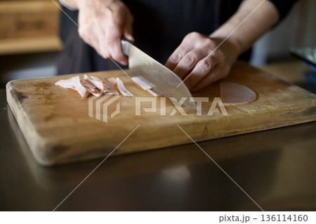 ハムを包丁で切っているところ 136114160