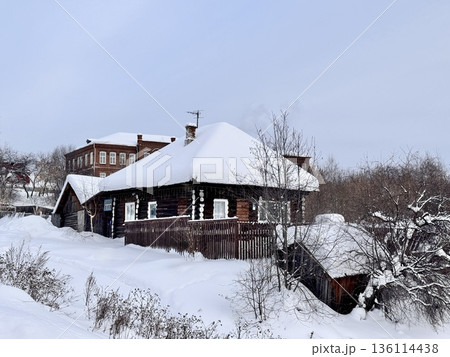 traditional Russian log cabin with carved architraves in winter in the village 136114438