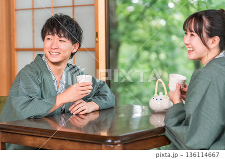 庭の景色が見える旅館の和室でお茶を飲む浴衣姿のカップル,夫婦 庭の景色が見える旅館の和室でお茶を飲む浴衣姿のカップル,夫婦 136114667