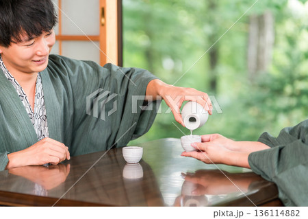 旅館の和室で浴衣姿でお酌する男女,夫婦,カップル 136114882