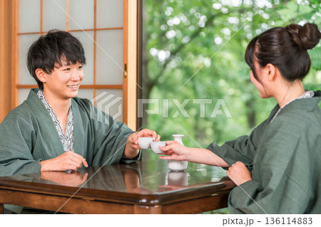 旅館の和室で浴衣姿でお酌する男女,夫婦,カップル（日本酒） 136114883
