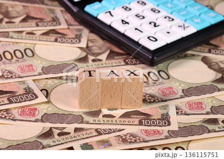 一万円札と電卓とTAXの文字ブロック（税金、確定申告イメージ） 136115751