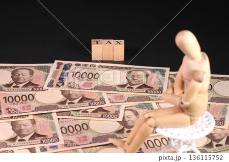 一万円札とTAXの文字ブロックと木製人形（税金、確定申告イメージ） 136115752