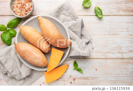 Raw sweet potatoes on plate, preparing healthy meal Raw sweet potatoes on plate, preparing healthy meal 136115939