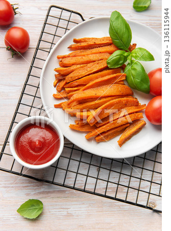 Sweet potato fries with ketchup and fresh basil Sweet potato fries with ketchup and fresh basil 136115944
