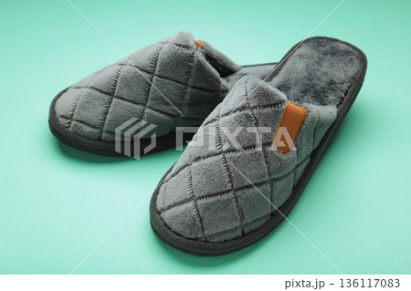 Household grey slippers on mint background. Space for text Household grey slippers on mint background. Space for text 136117083
