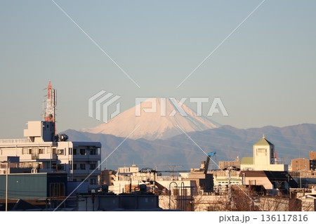 青空と冠雪した富士山と山並みと市街地の街並みの風景 136117816