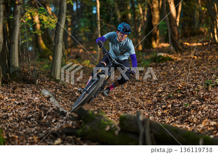 Mountain Biker Navigates Forest Trail in Autumn Colors and Gear Mountain Biker Navigates Forest Trail in Autumn Colors and Gear 136119738