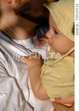 Baby in Yellow Hat Held by Adult Baby in Yellow Hat Held by Adult 136120318