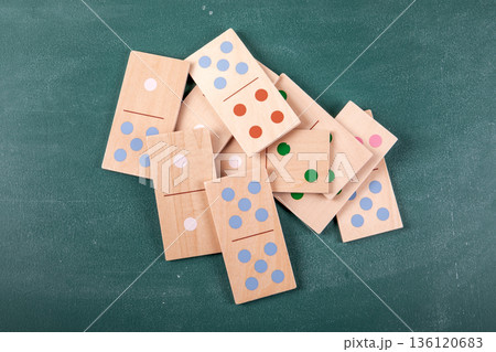 Wooden Domino Tiles Scattered On Green Tabletop Background 136120683