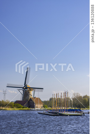 Traditional Dutch windmill by a lake in Warmond, Netherlands 136120888