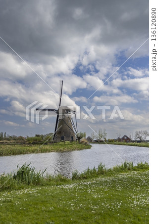 Traditional Dutch windmill standing by canal in Haastrecht Traditional Dutch windmill standing by canal in Haastrecht 136120890