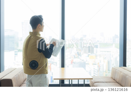 資料を見ながら打ち合わせする空調服の職人の男性 資料を見ながら打ち合わせする空調服の職人の男性 136121616